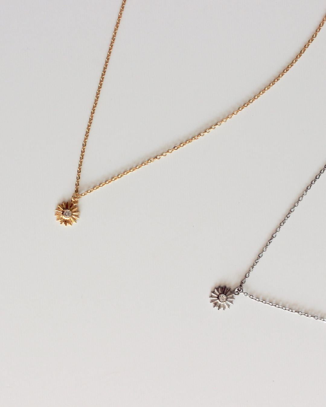 Catholic Eucharist Necklace available in gold and silver, layed on top of a white background.