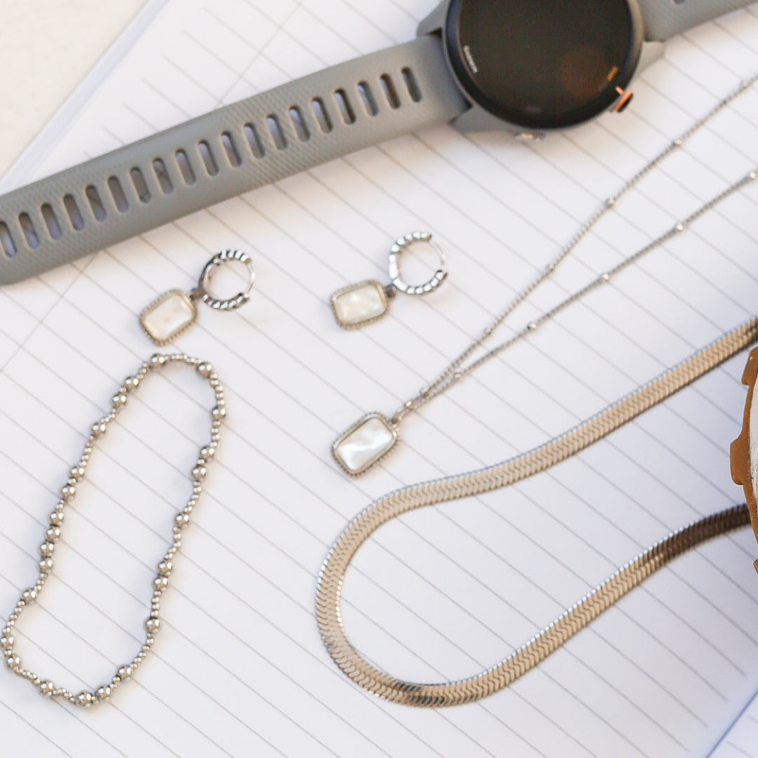 Silver jewelry laid on notebook
