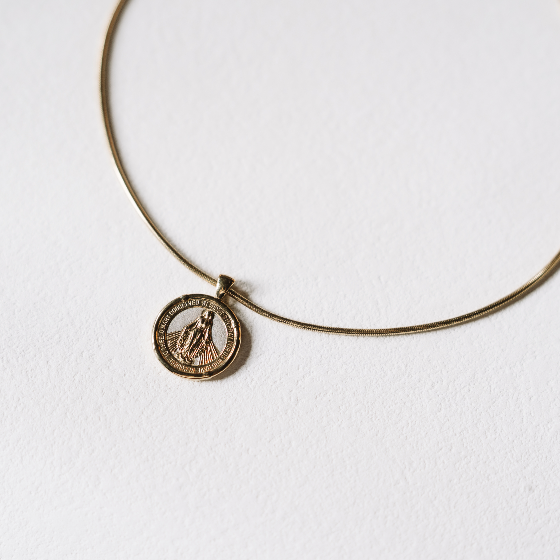 Gold necklace with a pendant on a white background