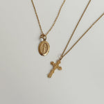 Two gold necklaces with pendants on a light gray background