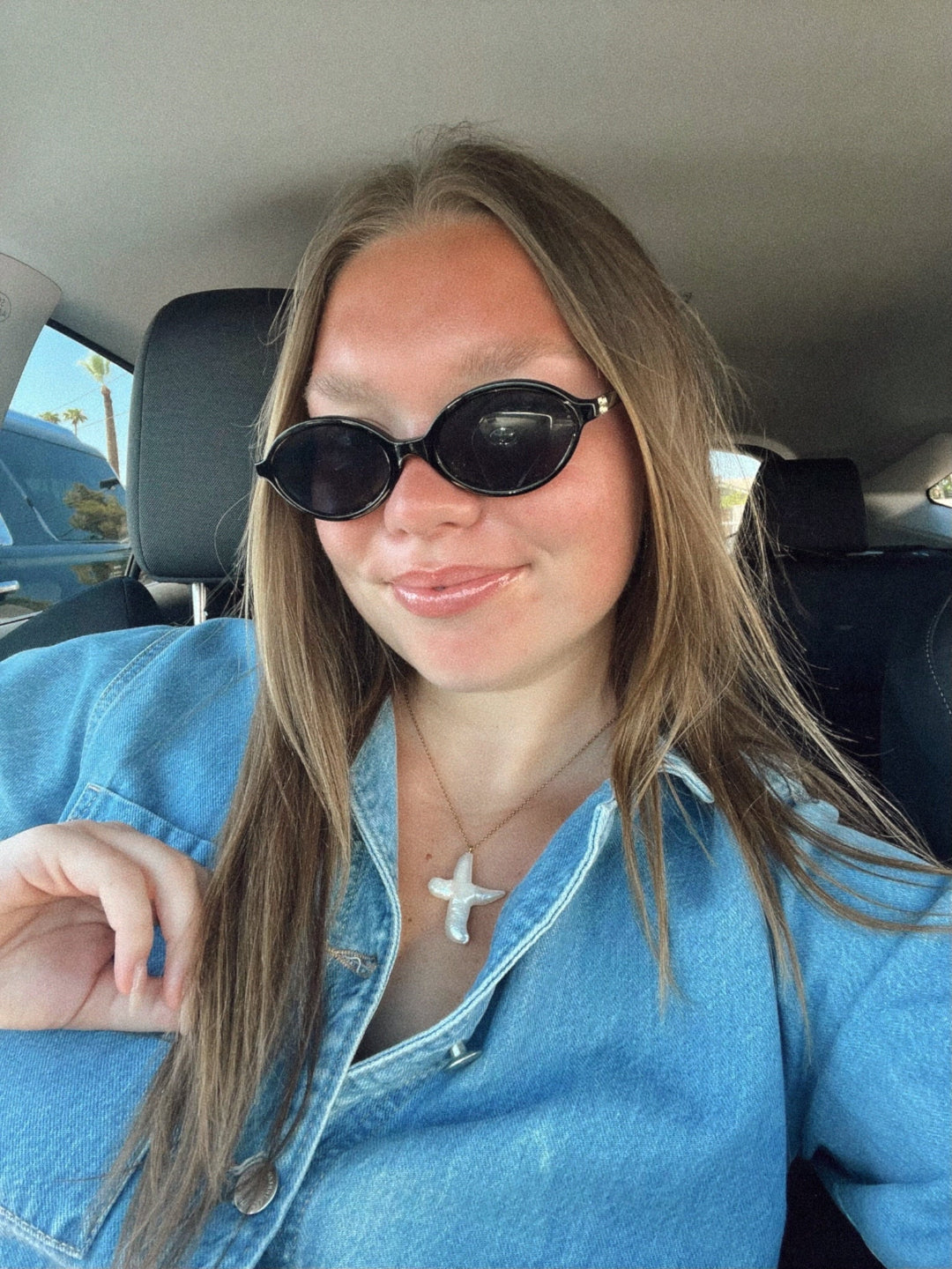 Brunette model styling necklace with denim