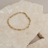 Gold beaded bracelet on rock