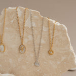 4 Catholic necklaces on rock