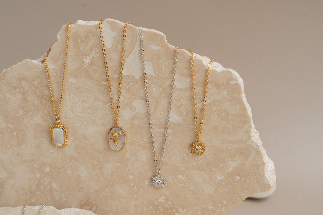 4 Catholic necklaces on rock