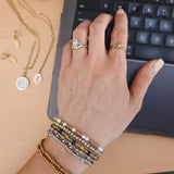 Hand on computer with rings and bracelets
