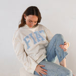 Model sitting with fiat mockneck and jeans