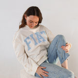 Model sitting with fiat mockneck and jeans