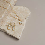 Gold earrings and necklace on rock