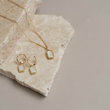Gold earrings and necklace on rock
