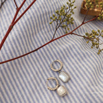 Silver huggies on stripped cloth