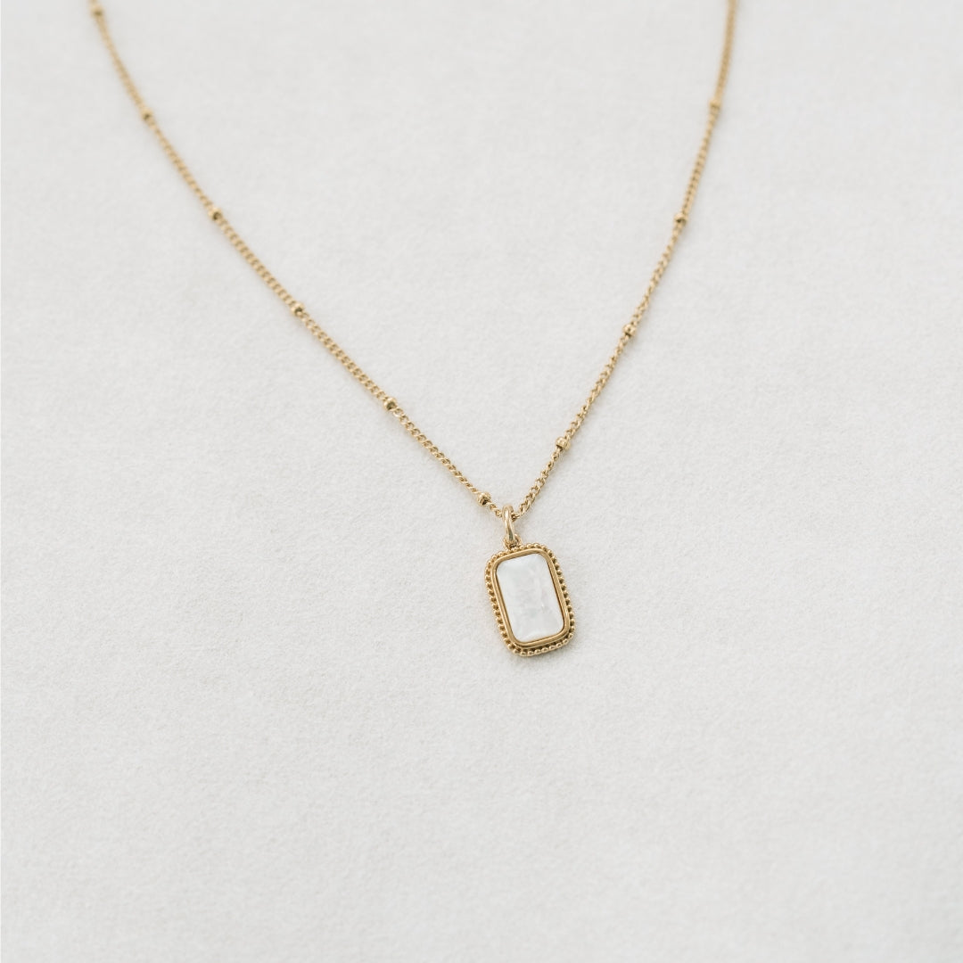 Gold foundation necklace white background