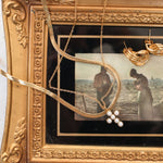 Gold slink with cross necklace on frame