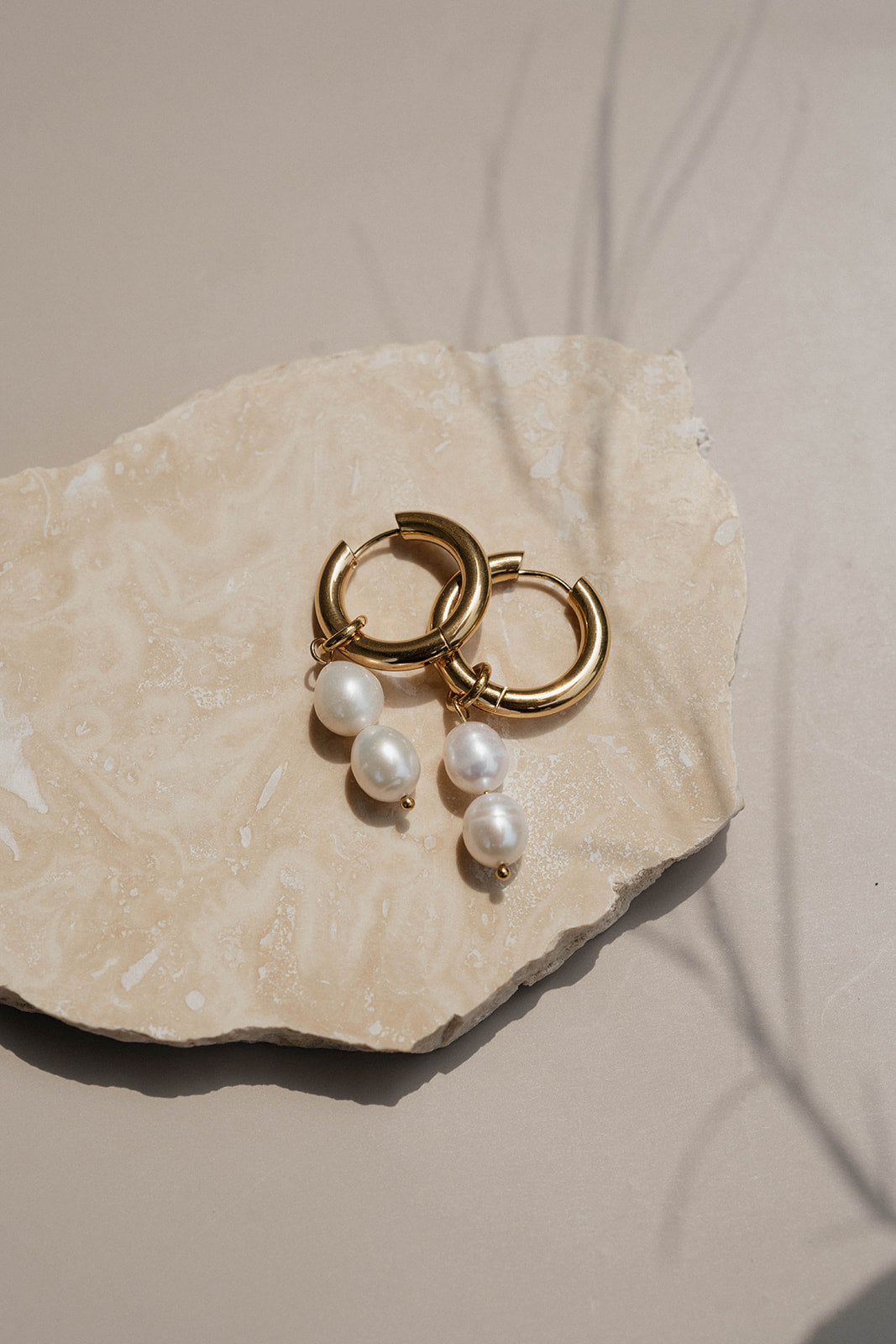 Gold pearl hoops on rock