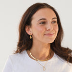 Brunette model in huggies and gold necklaces