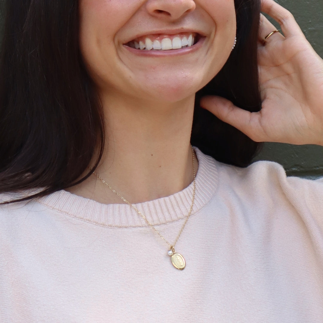 Gold miraculous medal being modeled