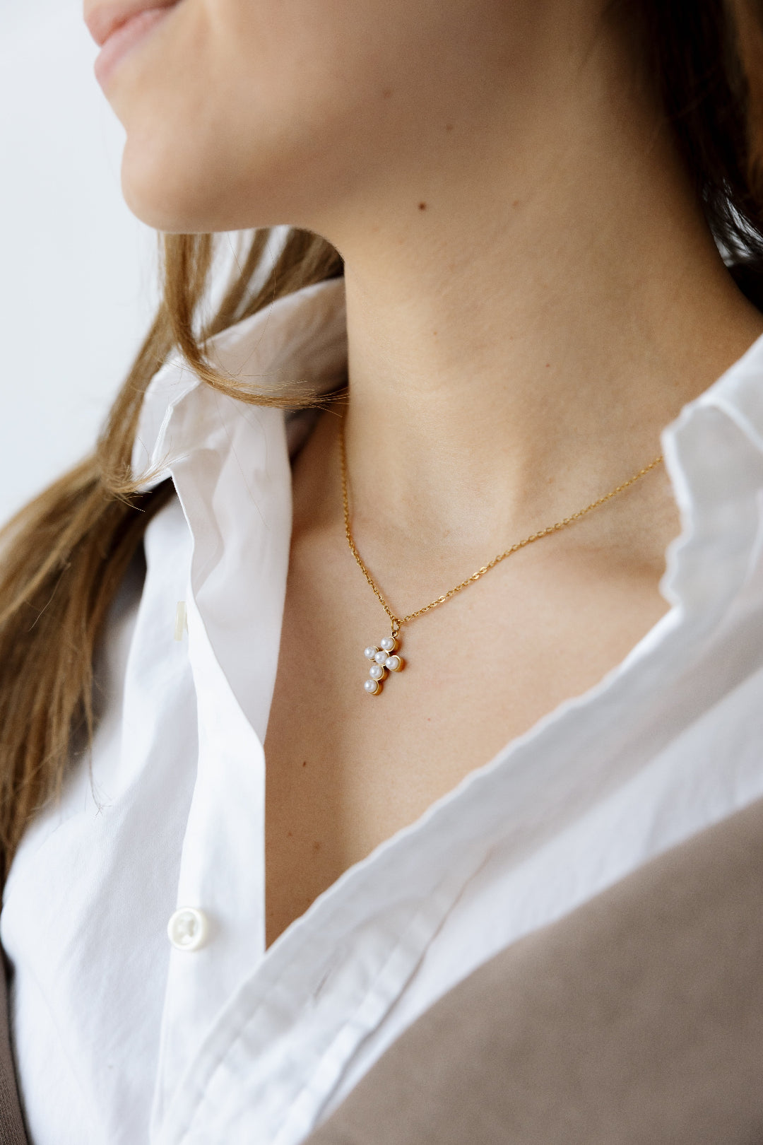 Cross necklace modeled with white top