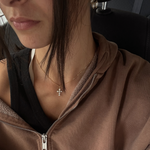 Model wearing earrings and cross necklace