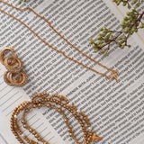 Bracelet stack with earrings and necklace on Bible