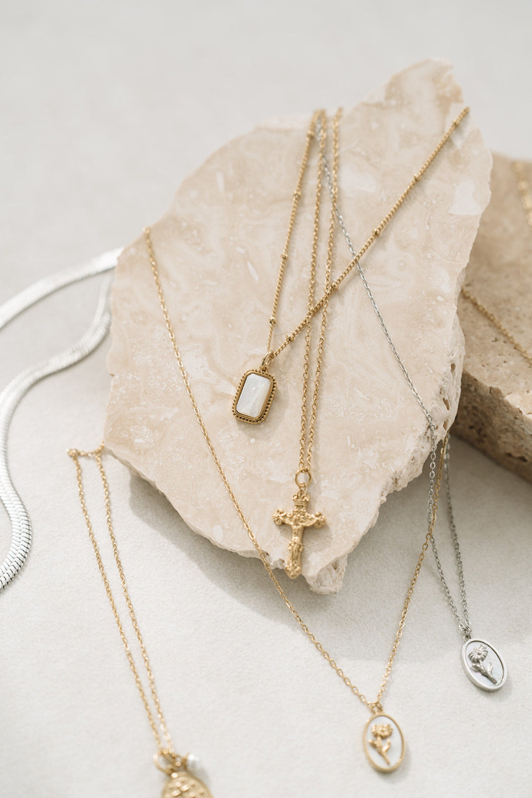 Gold catholic necklaces on rock